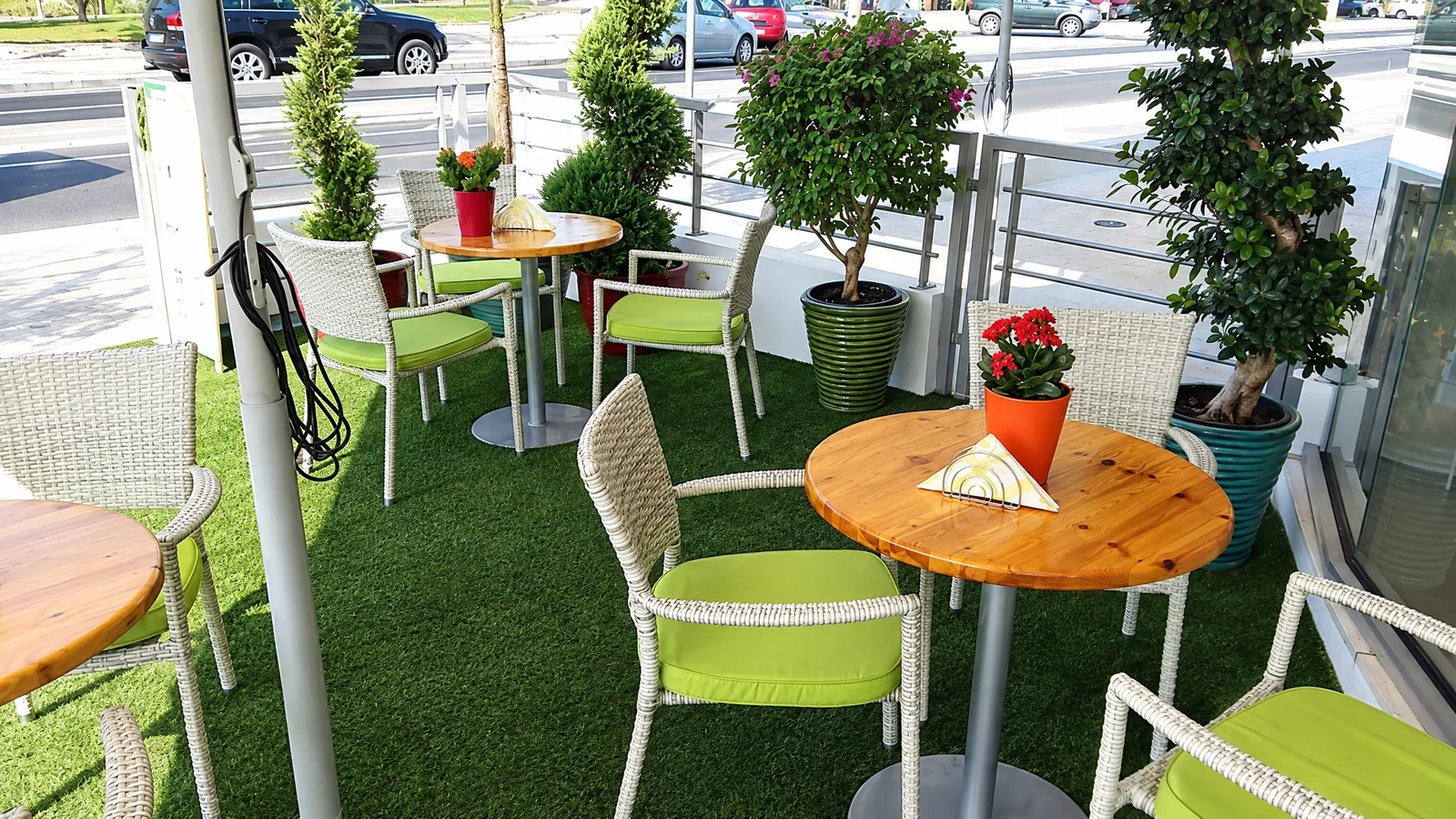 The Begonia Garden Café terrace with green chairs and potted trees