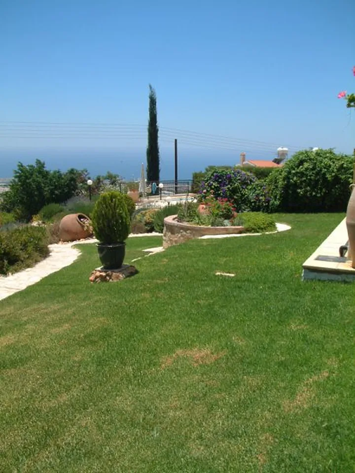 Lawn with cypress trees and a sea view